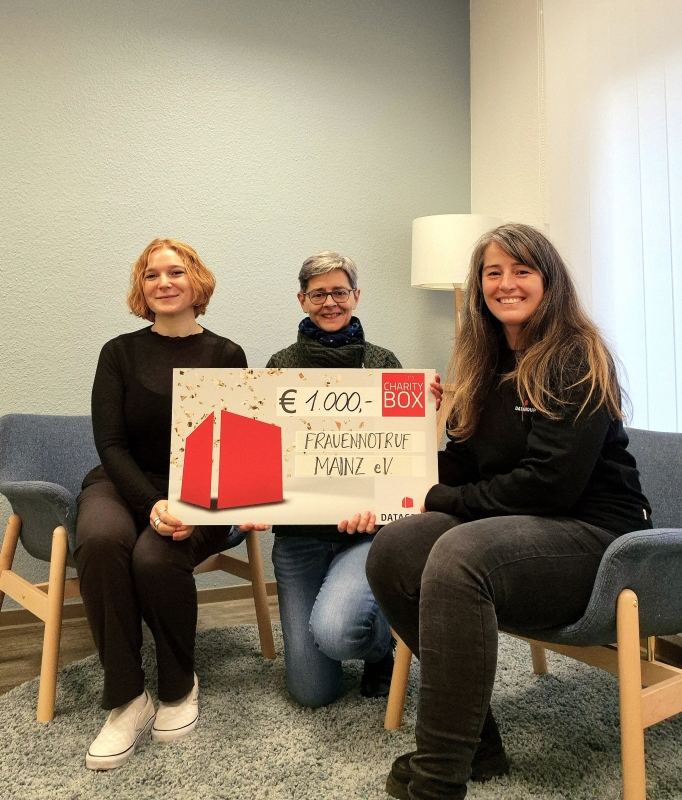 Leah Krieger (l.) und Eva Jochmann (m.) vom Frauennotruf Mainz bei der symbolischen Spendenübergabe von Marta Wojcik (r., DATAGROUP)